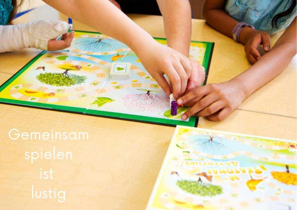 Kinder spielen zusammen ein Brettspiel.