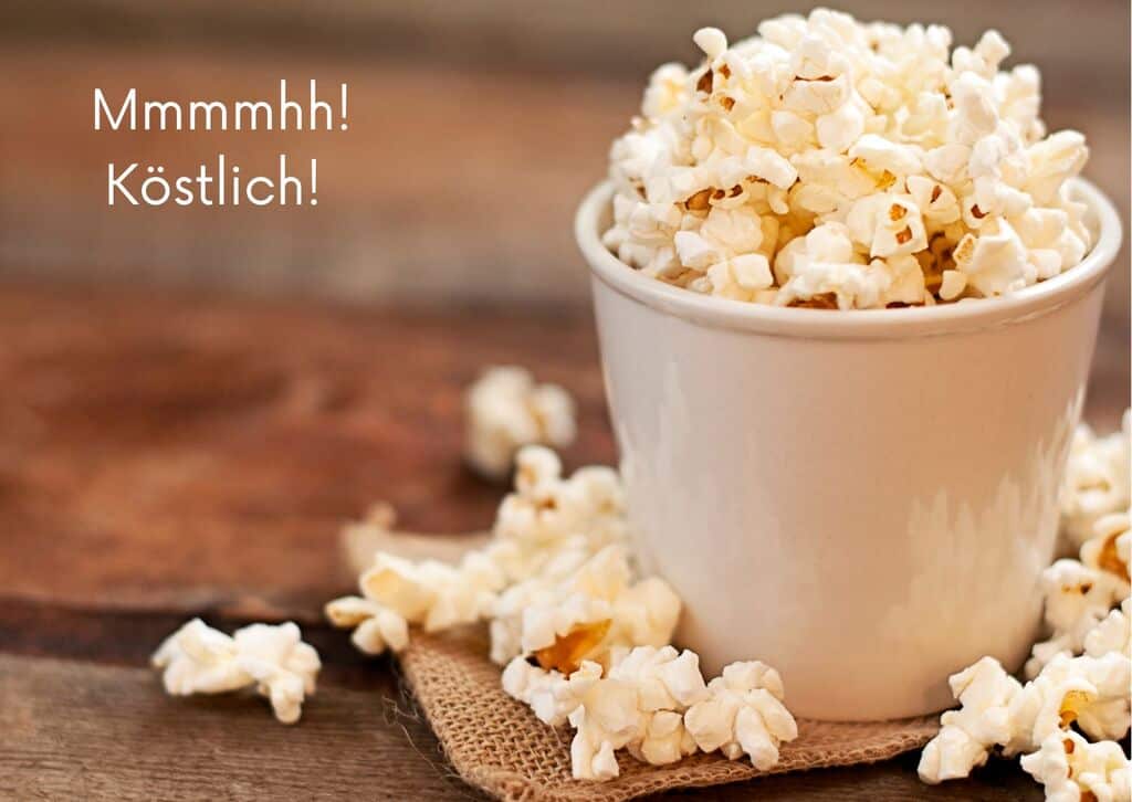 Eine Tasse gefüllt mit Popcorn steht auf dem Tisch.