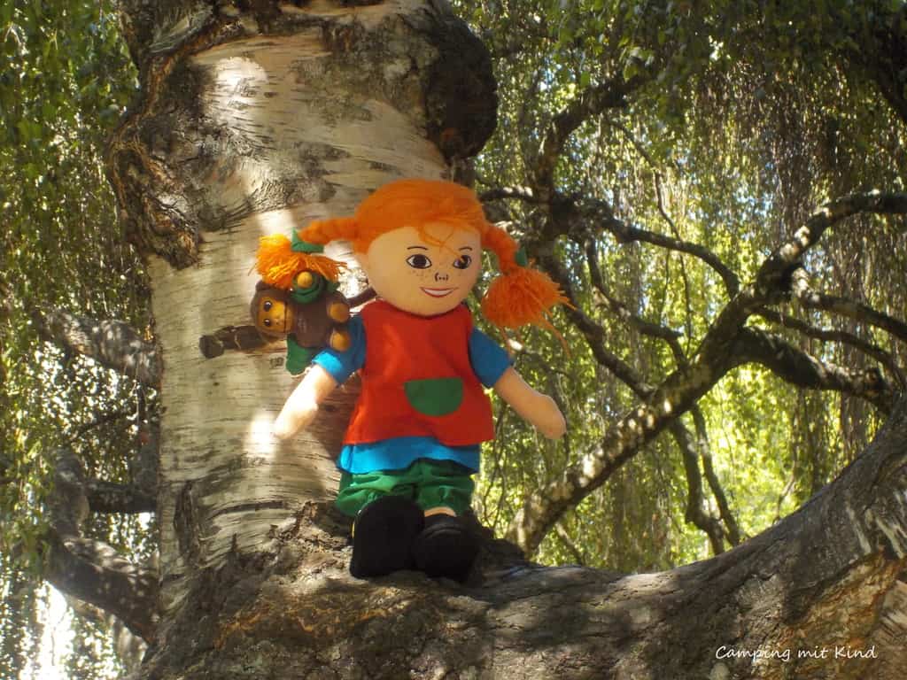 Pippi Langstrumpf sitzt im Baum.