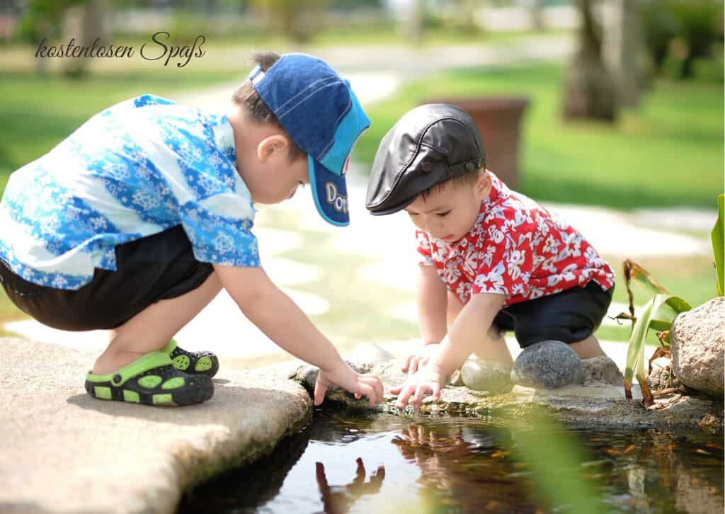 Zwei Kinder spielen am Fluss.