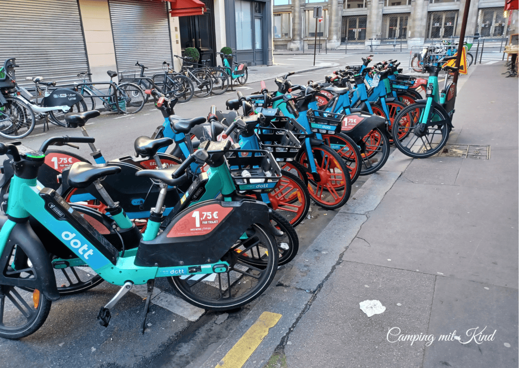 E-Bike-Verleih in Paris: Sharing-Fahrräder an einer Mietstation. Elektrische Leihfahrräder mit Preisschild auf einer Pariser Straße.