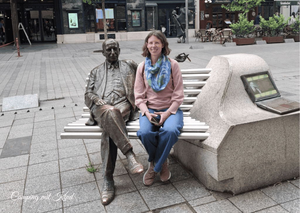 Eine Statue sitzt auf einer Bank
