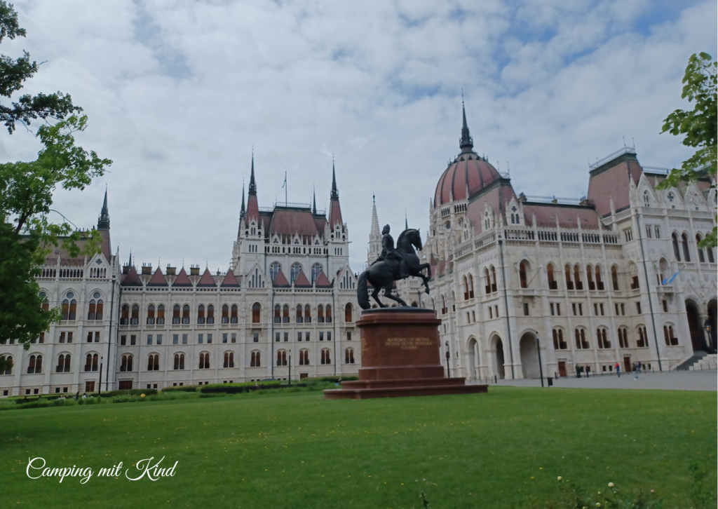 Eine Pferdestatue befindet sich vor einem großen Gebäude