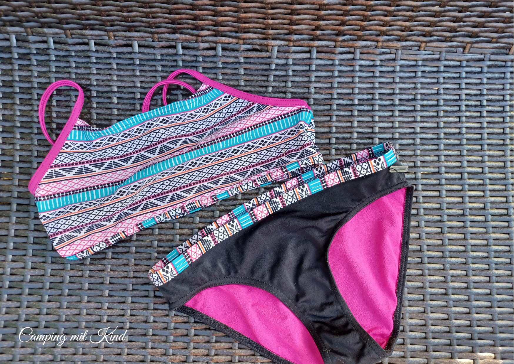 Eine Bikinihose und ein Bikinioberteil liegen auf einer braunen Bank.
