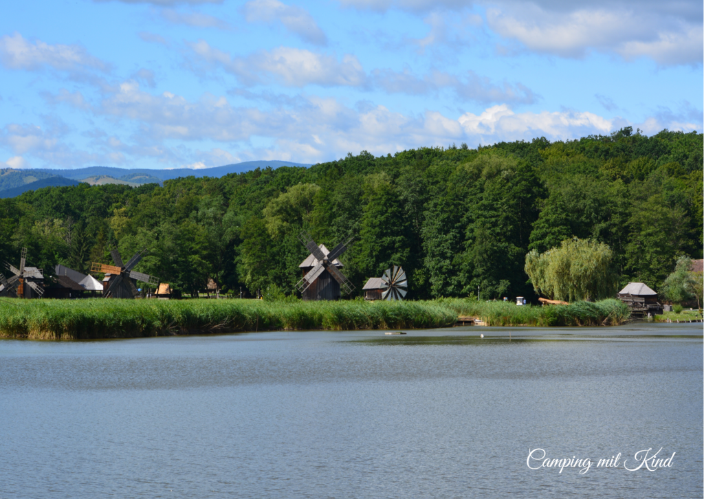 Ein See und dahinter Windmühlen