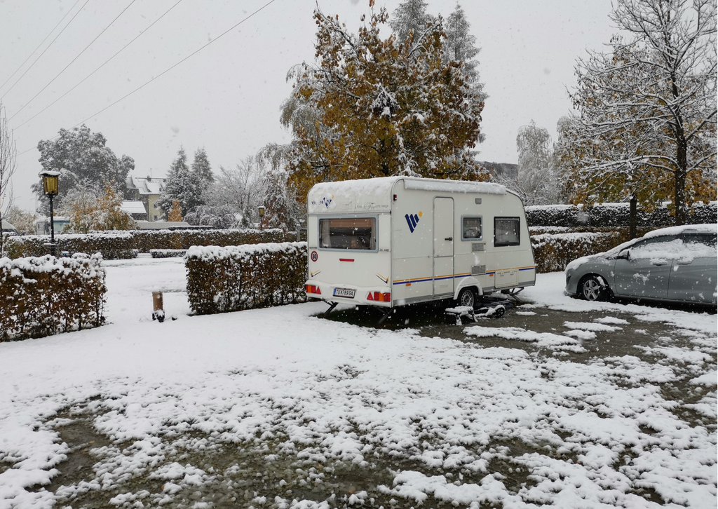 Ein Wohnwagen steht auf einer verschneiten Wiese