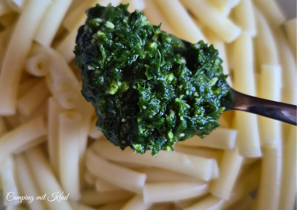 Nudeln mit einem Löffel voller grünem Bärlauchpesto