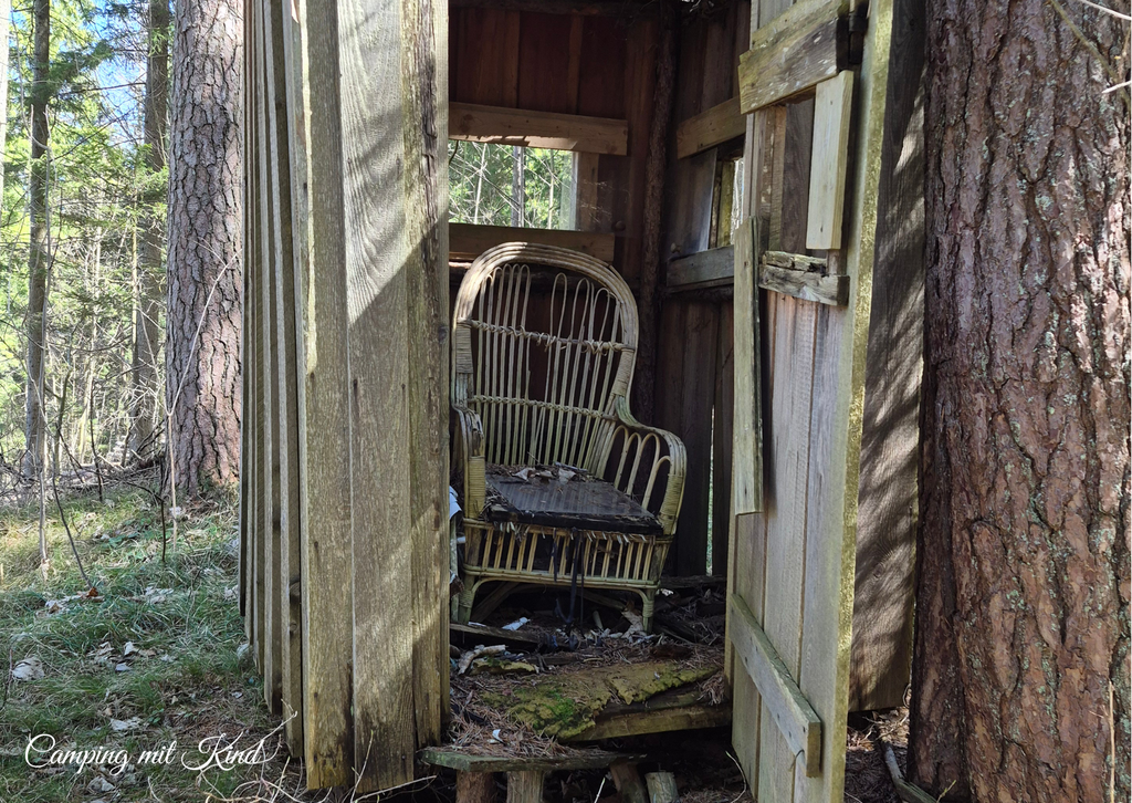 Ein zerfallener Thron steht in einer alten Holzhütte