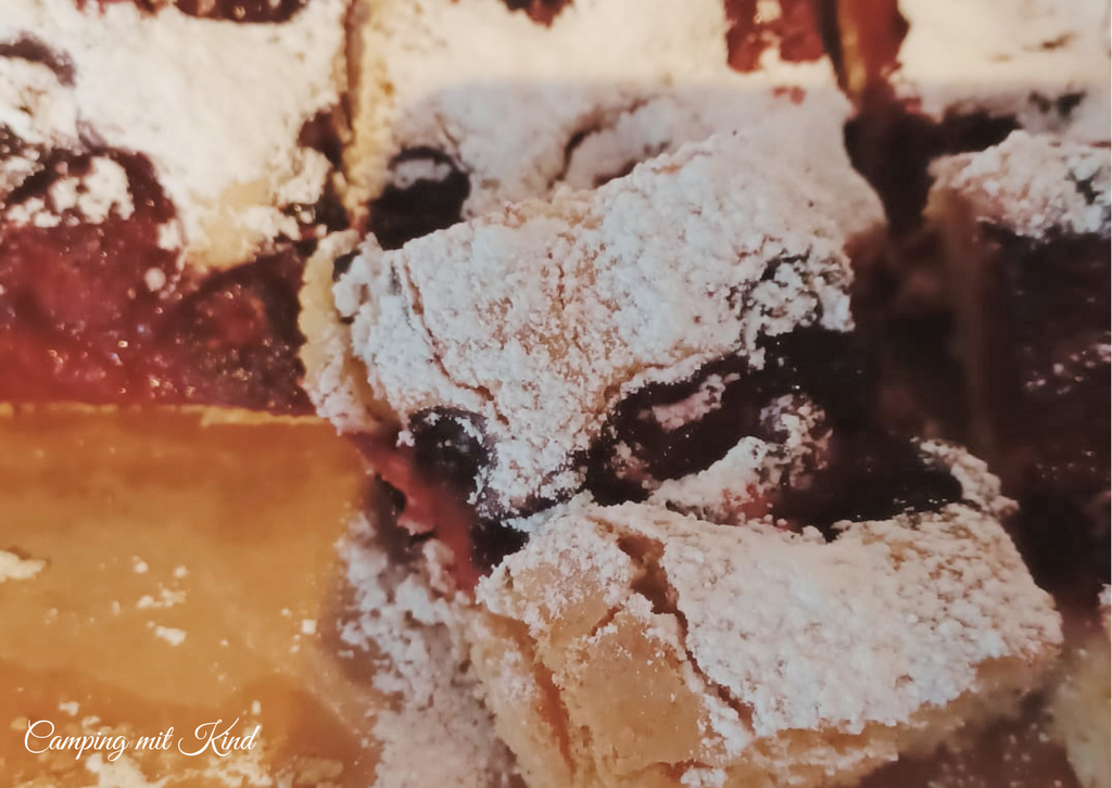 Auf einem Teller befindet sich ein Kuchen mit viel Staubzucker